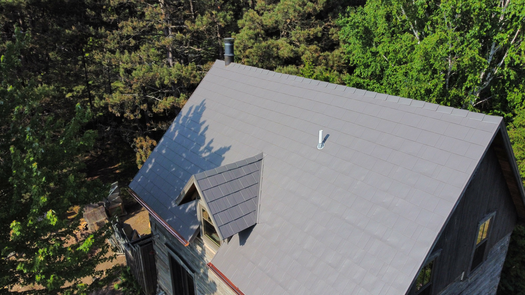 Aerial shingle roof surrounded by Northern Michigan forest